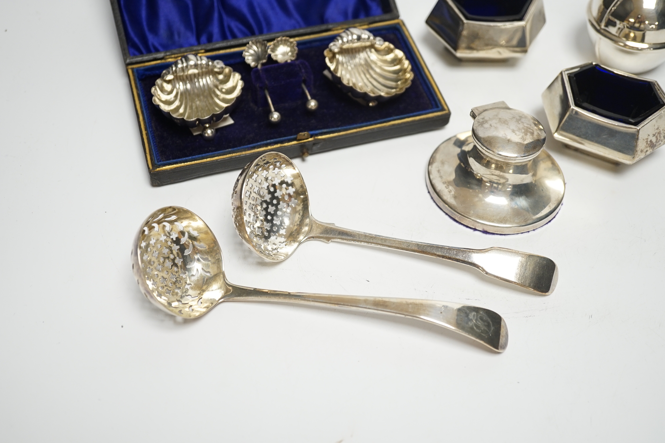 A cased pair of silver salts, one other pair of salts, a Guernsey miniature silver milk jug, an inkwell and two silver sifter ladles.